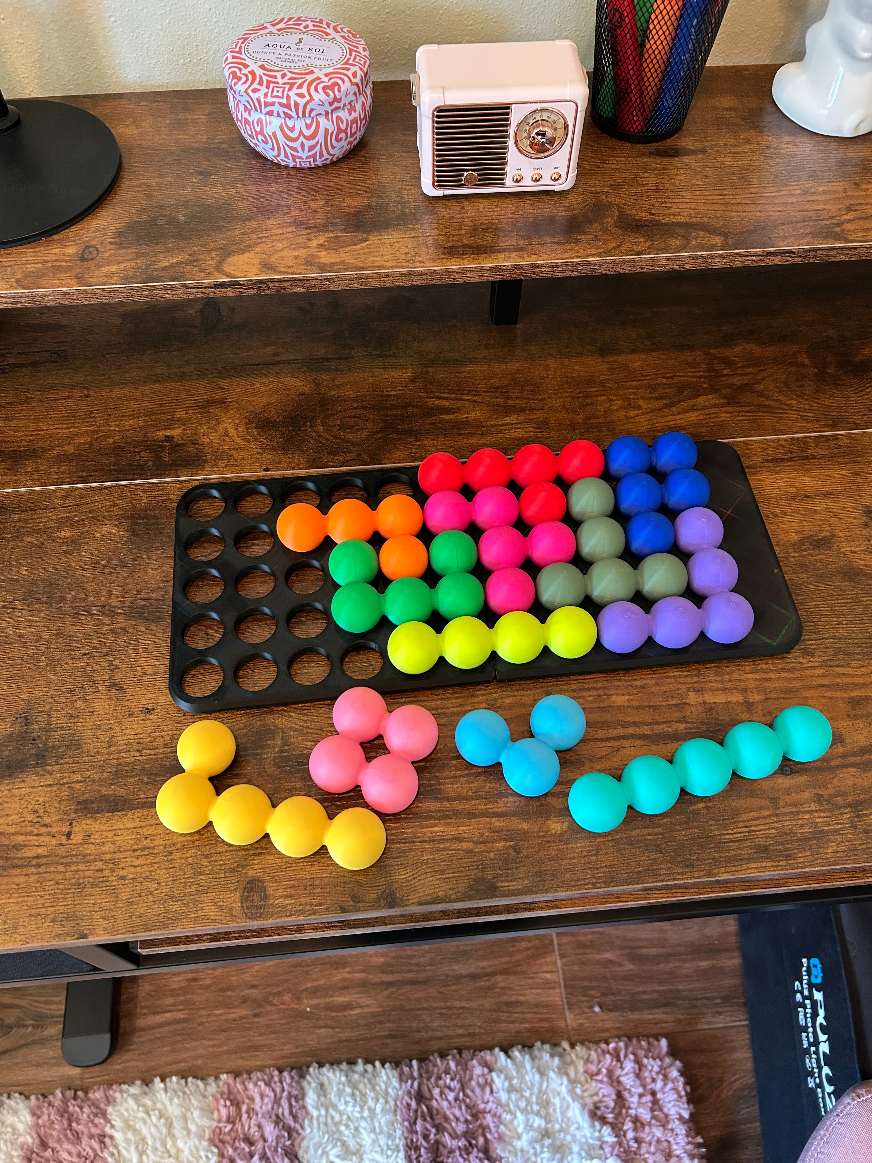 Katachi-Go pieces scattered on a desk next to a partially solved tray